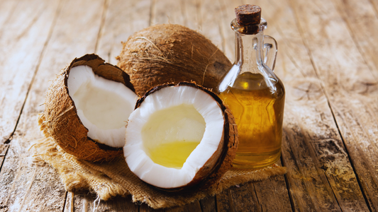 An open coconut and a corked bottle of oil