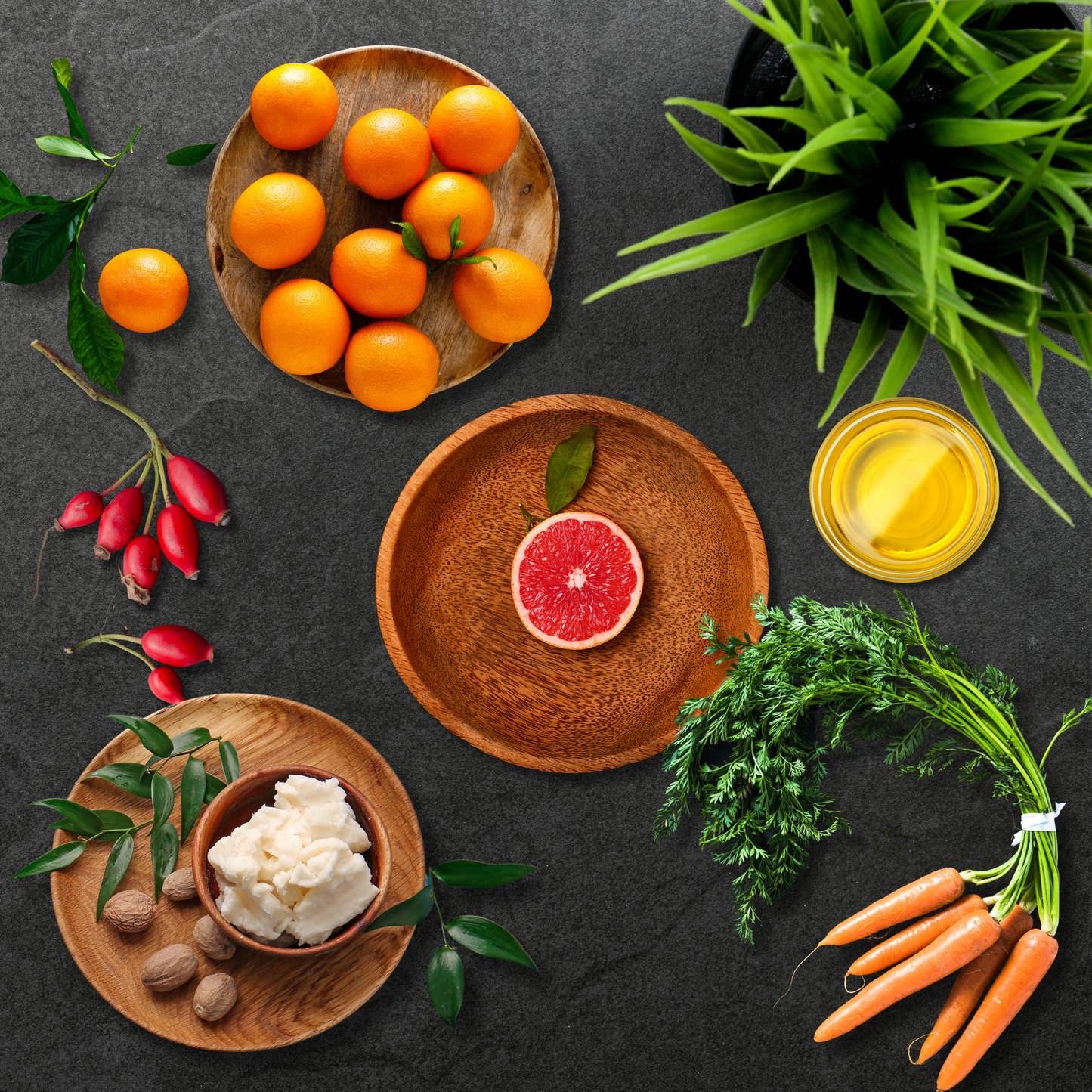 Pink grapefruit, tangerines, rosehip, carrots, oil and Shea butter on a dark table